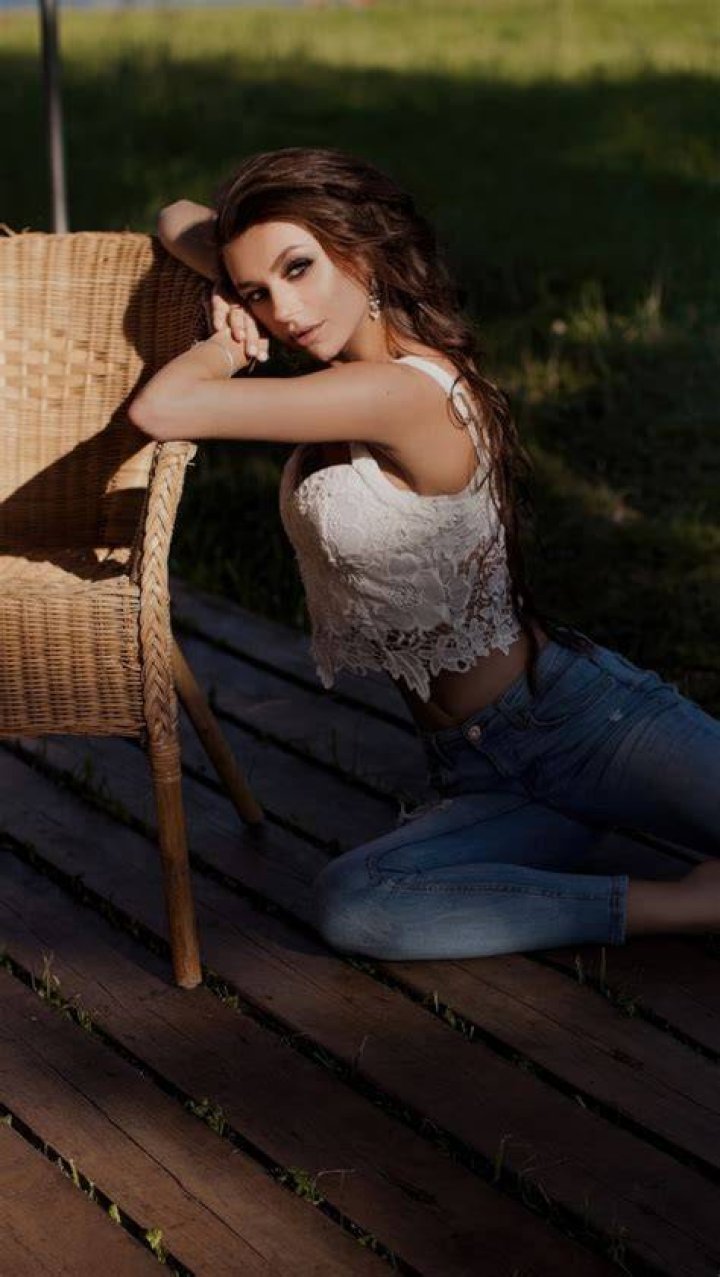 kaia gerber elle cover shoot february 2023 a white brunette model sits on the beach in a gold dress and black boots