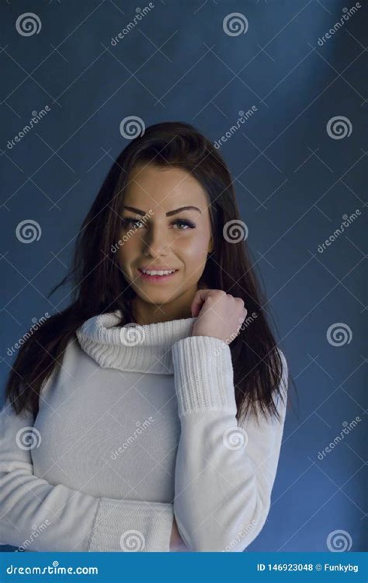 kaia gerber elle cover shoot february 2023 a white brunette woman wearing a white knit set and sunglasses, with her hands and arms playfully posed in brown boots