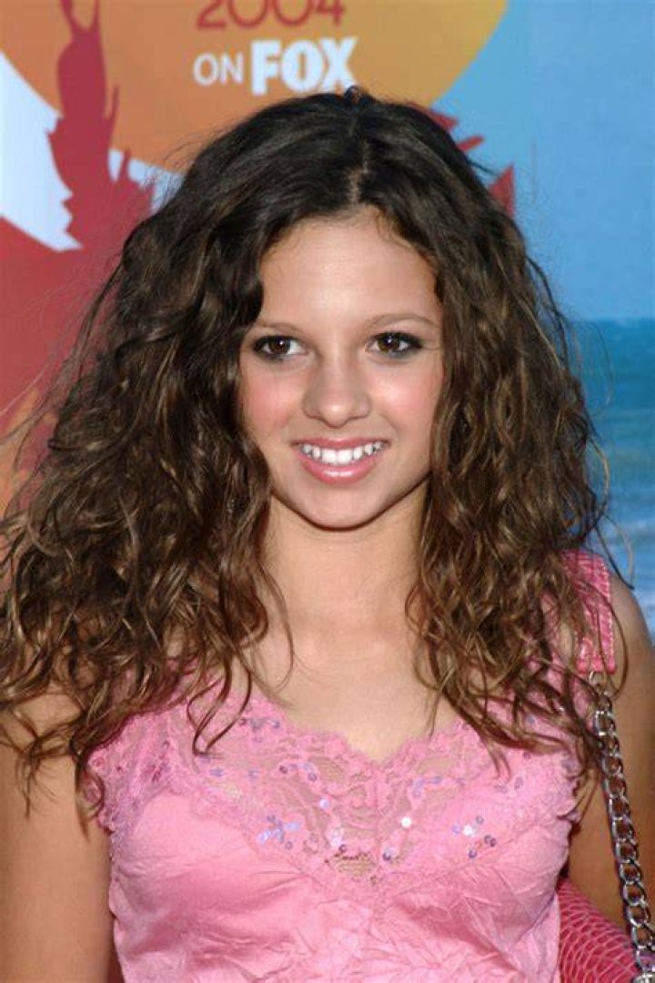 Mackenzie Rosman smiling in front of a black background