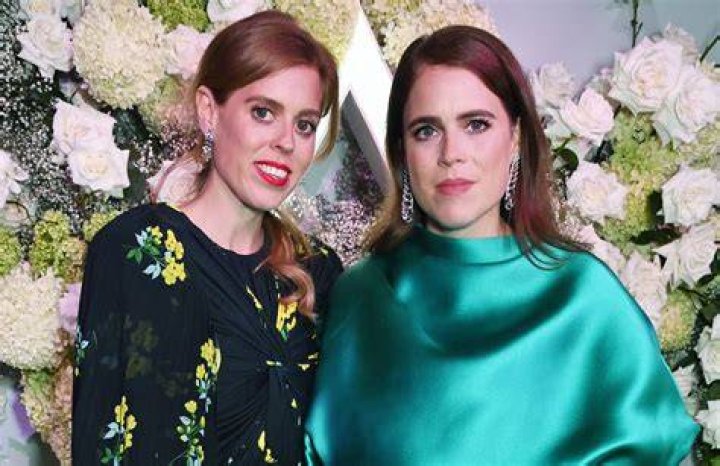 Princess Eugenie smiling in a plaid coat at night