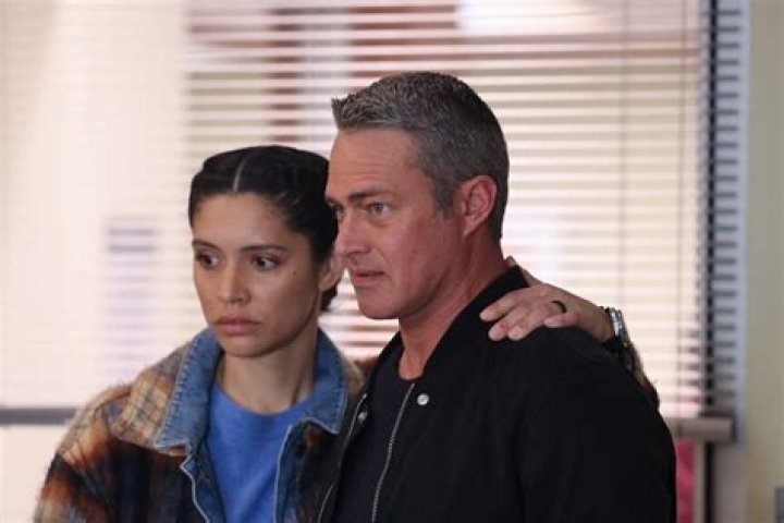 Stella Kidd and Taylor Kinney standing next to each other, each holding coffee cups
