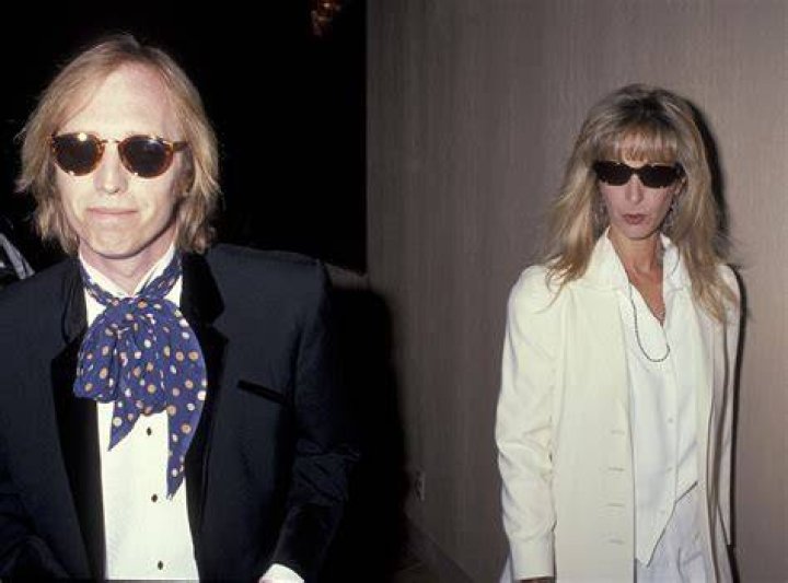 Tom Petty, Jane Benyo, and their two daughters sit on a couch together.